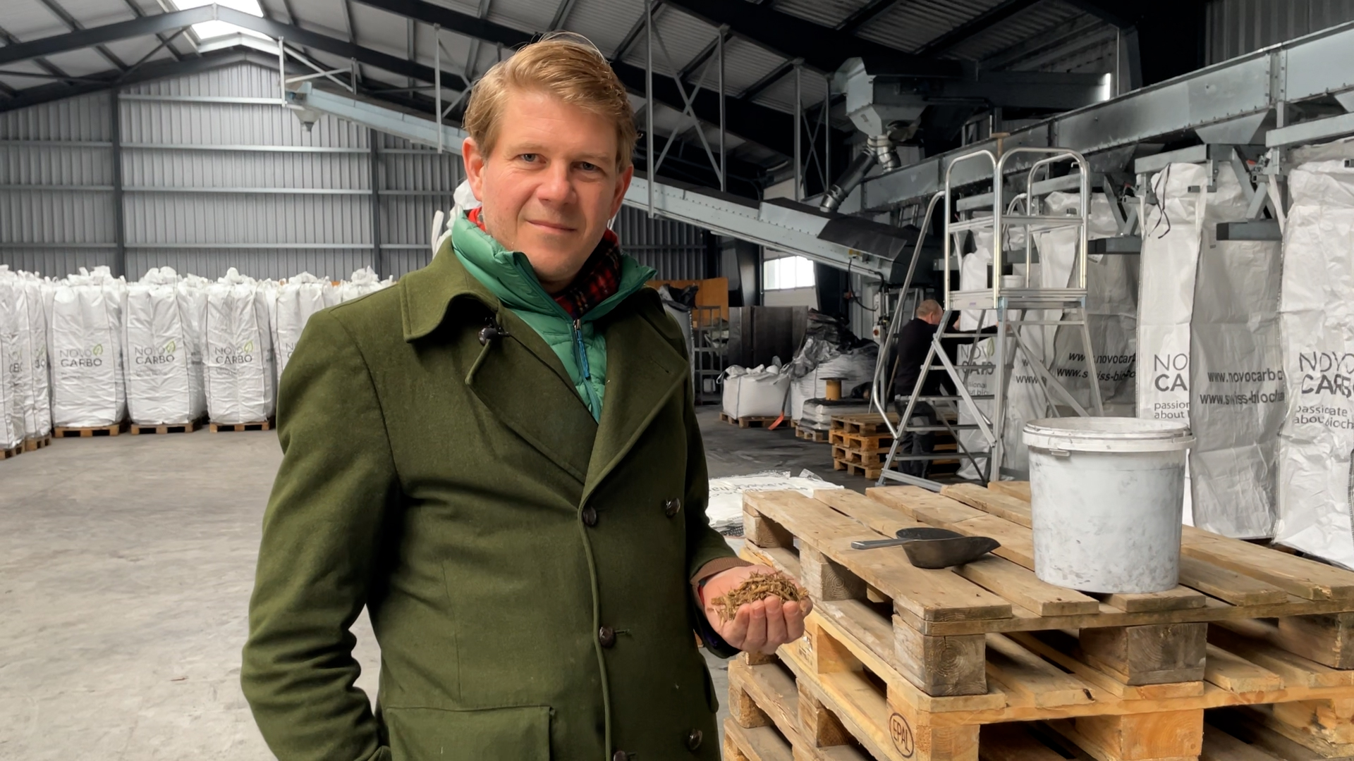 Florian Lage holding biomass at the biochar production