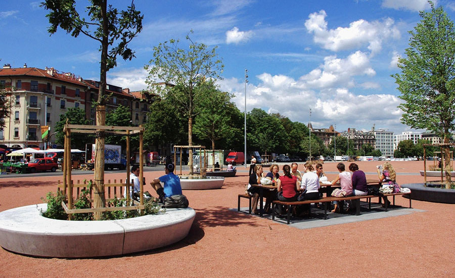 People sitting in a recreational area with the city Geneva in the background.